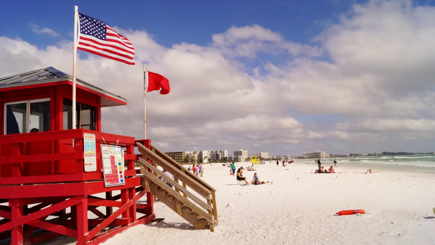 Bright red lifeguard stand on the white sand of Siesta Beach